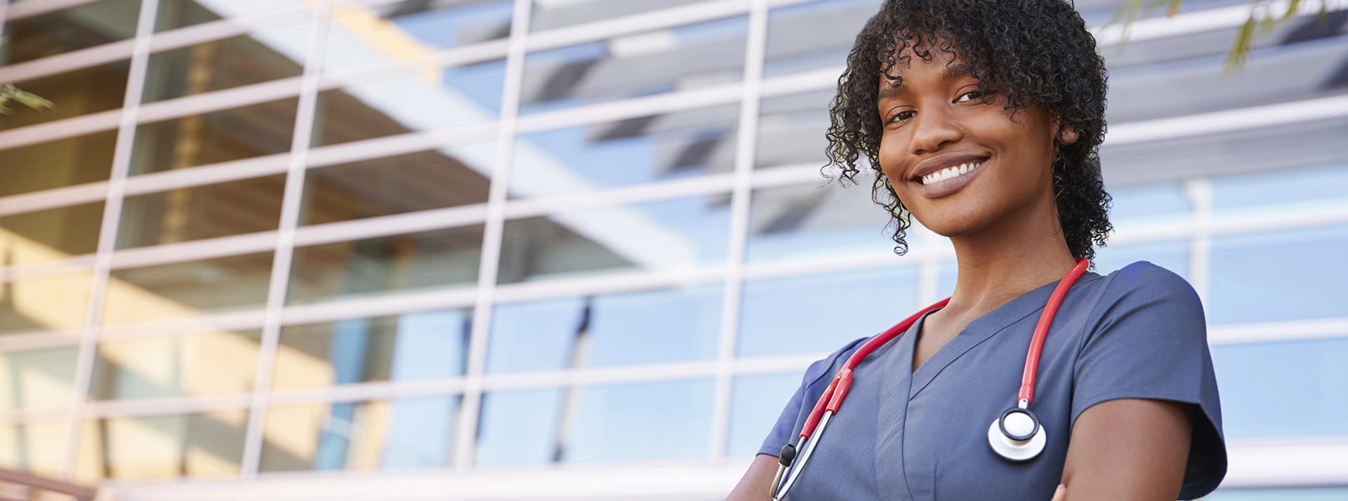A nursing student poses with her scrubs and a stethoscope.