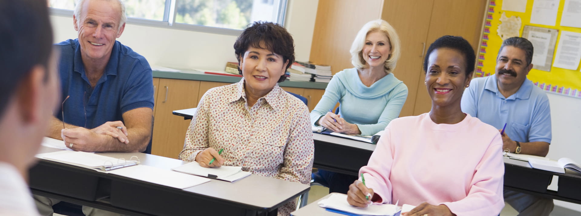 A classroom of adults watch their instructor